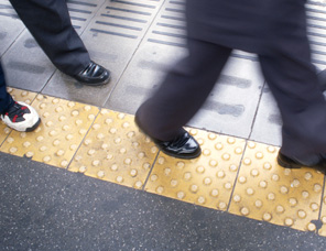 歩行者が歩く足元にナビゲーションの役割を果たす点字版があるイメージ画像